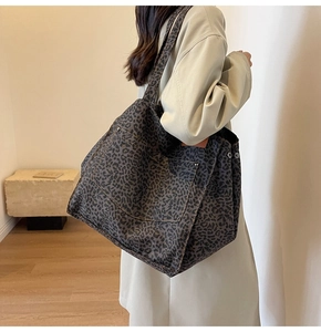Close-up of the large front pocket and leopard print pattern on the canvas tote bag