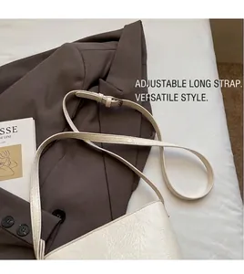 Vue détaillée de la bandoulière réglable sur un sac seau blanc à texture plissée