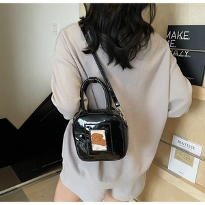 Detail of black patent leather crossbody bag with cute cartoon card slot and silver hardware