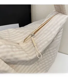 Close-up of smooth zipper closure on striped canvas tote bag showing detailed texture