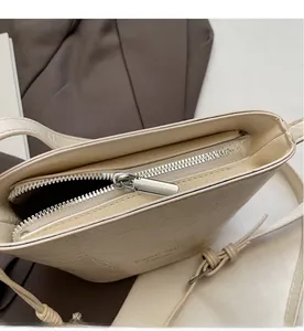 Détail du zip argenté fluide et de la texture plissée du sac seau crème