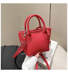 Close-up of red lychee textured mini square handbag with silver hardware and side knot