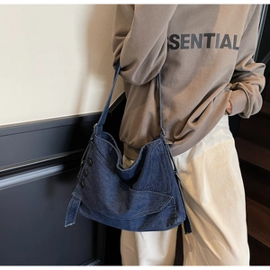 Detail of dark blue denim tote bag featuring vintage metal buttons and layered cargo pockets