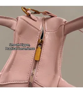 Detail of smooth gold metal zipper and pink textured leather on a large shoulder bag