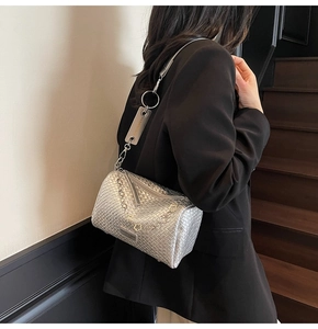 Detail of silver woven cylinder crossbody bag with flower metal chain and fashion tag