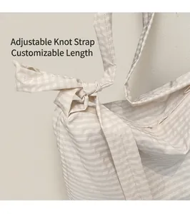 Detail of adjustable knotted shoulder strap on striped canvas tote bag