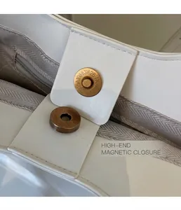 Detail of the vintage gold magnetic clasp and gray lining of the white tote bag