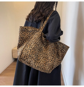 Close-up of leopard print canvas tote bag with metal snap button and long shoulder straps
