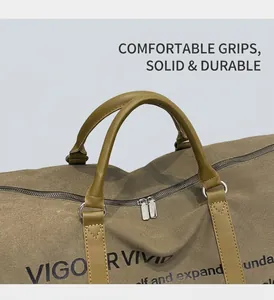 Close-up of khaki canvas travel bag featuring brown leather handles and dual silver zippers