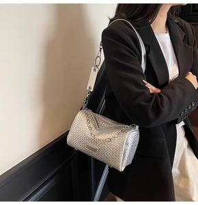 Detail of silver woven barrel bag with metallic chain strap and fashion label detail