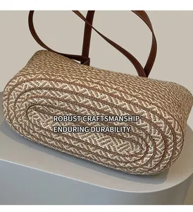 Detail view of durable woven base and brown leather strap of the straw tote bag