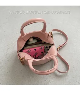Detail view of pink leather handbag interior showing large storage space for phone and wallet