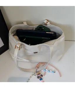 Spacious interior of white PU leather tote bag with tablet and phone for storage detail