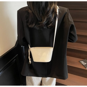 Vue détaillée d'un sac seau blanc en cuir texturé avec bandoulière à nœuds pour femme