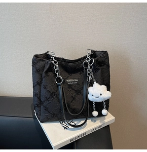 Detail of black pleated tote bag with silver chain strap and white cloud charm decoration