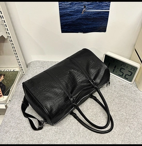 Detailed view of black crocodile pattern leather tote bag with sturdy carry handles