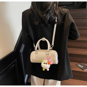 Detail of cream Boston bag with plush eye charm on vintage staircase setting