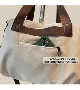 Detail view of the back zipper pocket on the large cream canvas tote bag for storage