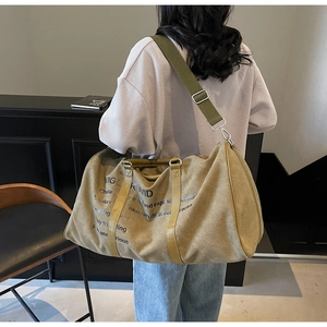 Detail of khaki canvas travel tote with VIGORWID print and adjustable shoulder strap