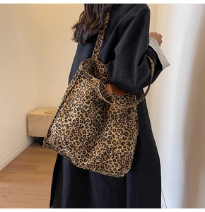 Leopard print canvas tote bag shown on shoulder of a model in a minimalist setting