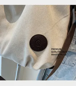 Detail of round leather logo patch on water-resistant travel bag with shoulder strap