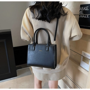 Modern black PU tote bag with metal logo, dual handles and slim detachable shoulder strap