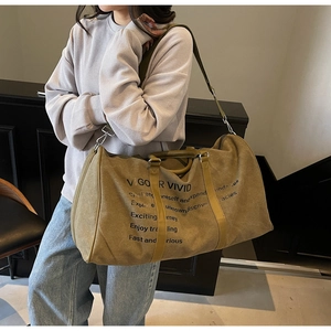 Olive green canvas travel bag with leather handles and Vigor Vivid printing shown on shoulder