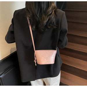 Détail du sac seau rose avec texture plissée et gaufrage Fashion sur un escalier en bois