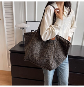 Detailed view of leopard print canvas tote bag with metal rivets and large front pocket