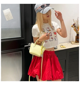 Sac à main jaune texture litchi avec jupe rouge et t-shirt blanc imprimé Hello Kitty
