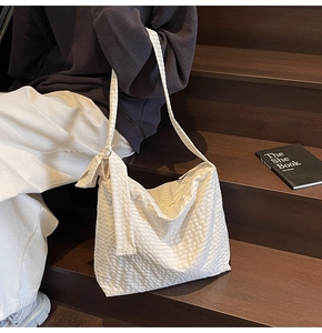 Close-up of off-white textured waffle fabric tote bag with stylish knotted strap detail
