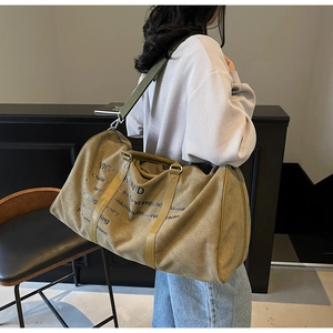 Canvas travel tote bag worn by model showing large capacity and adjustable strap detail