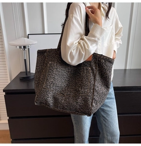 Close-up of leopard print canvas tote bag with front pocket and rivet details