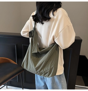 Detail of green plaid tote bag showing spacious capacity and decorative shoulder bow