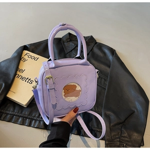 Detail view of purple patent leather bag featuring a cute cartoon dog window design