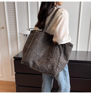 Detail of the leopard print canvas tote bag featuring front pocket and metal rivets
