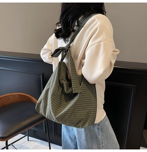 Detail of green plaid canvas tote bag with a stylish bow knot on the shoulder strap