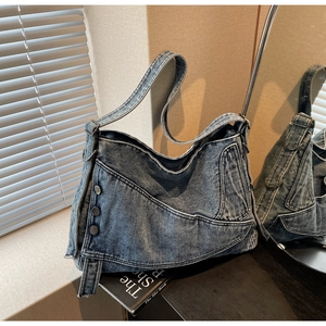 Detail view of denim tote bag showing reconstructed vintage pocket and metal button accents