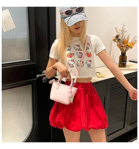 Détail du sac seau rose en similicuir avec pendentif cœur argenté et bandoulière