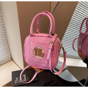 Detailed macro of pink patent leather handbag with bear window and ruffle edge design