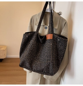 Detailed macro view of leopard print tote bag canvas material and metallic rivet studs