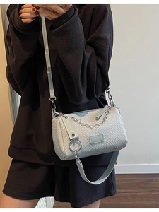 Light blue woven barrel bag with metallic chain strap and dual shoulder straps for women