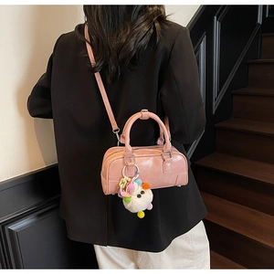 Pink PU leather bowling bag with a cute plush doll charm shown on a stylish model