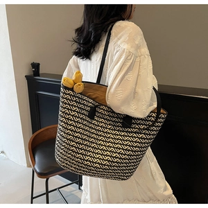 Detail of hand-woven tote bag with black and white stripes and faux tulip decoration