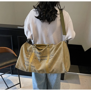 Rear view of large khaki canvas travel bag with brown handles and adjustable shoulder strap