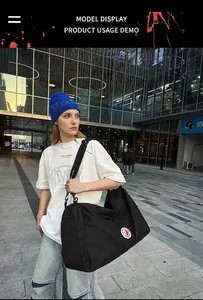 Outdoor male model shot showing the large black nylon tote bag with red circular logo