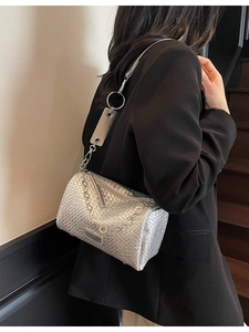 Silver woven crossbody pillow bag with floral metal chain and fashion brand tag
