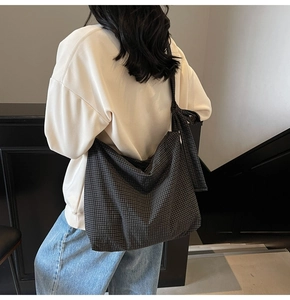 Detail of checkered tote bag with bow knot strap worn on shoulder for daily commute