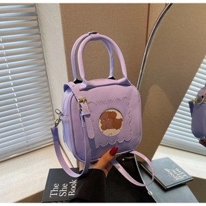 Close-up of lilac square crossbody bag with puppy print window and glossy finish