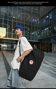 Detail of waterproof nylon tote bag showing the circular logo and adjustable strap